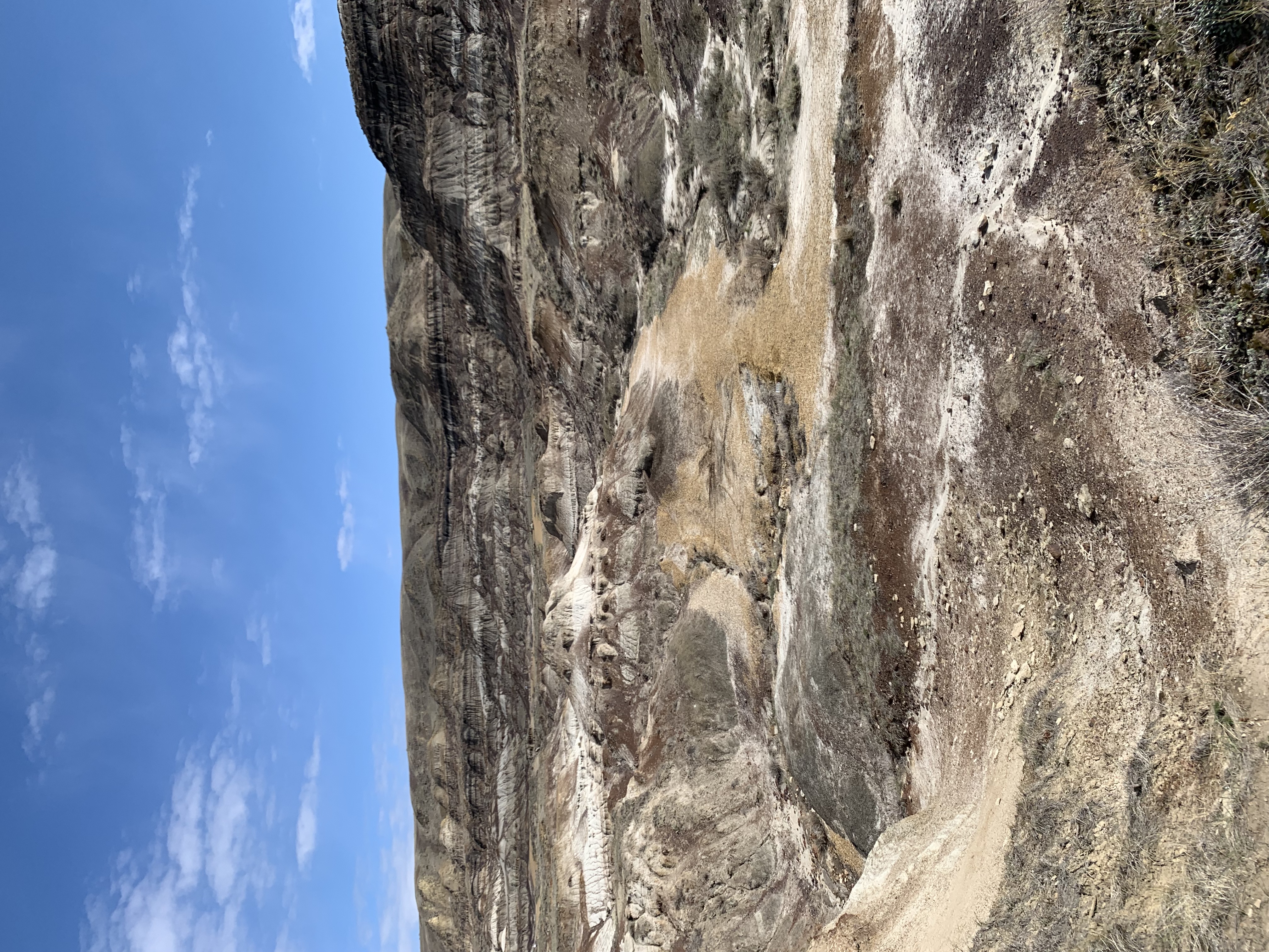 A badlands landscape, showing rock formations and sedimentary layers.