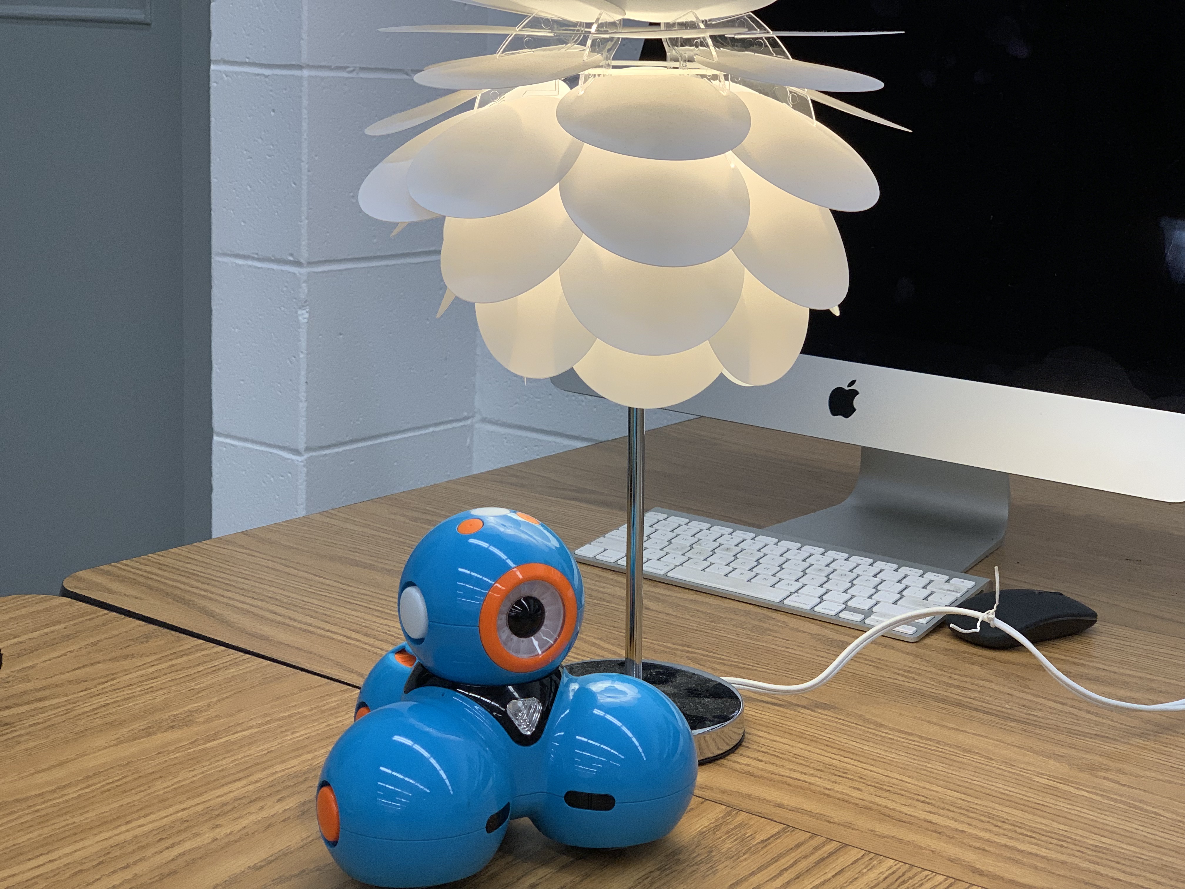 A small blue robot on a table.