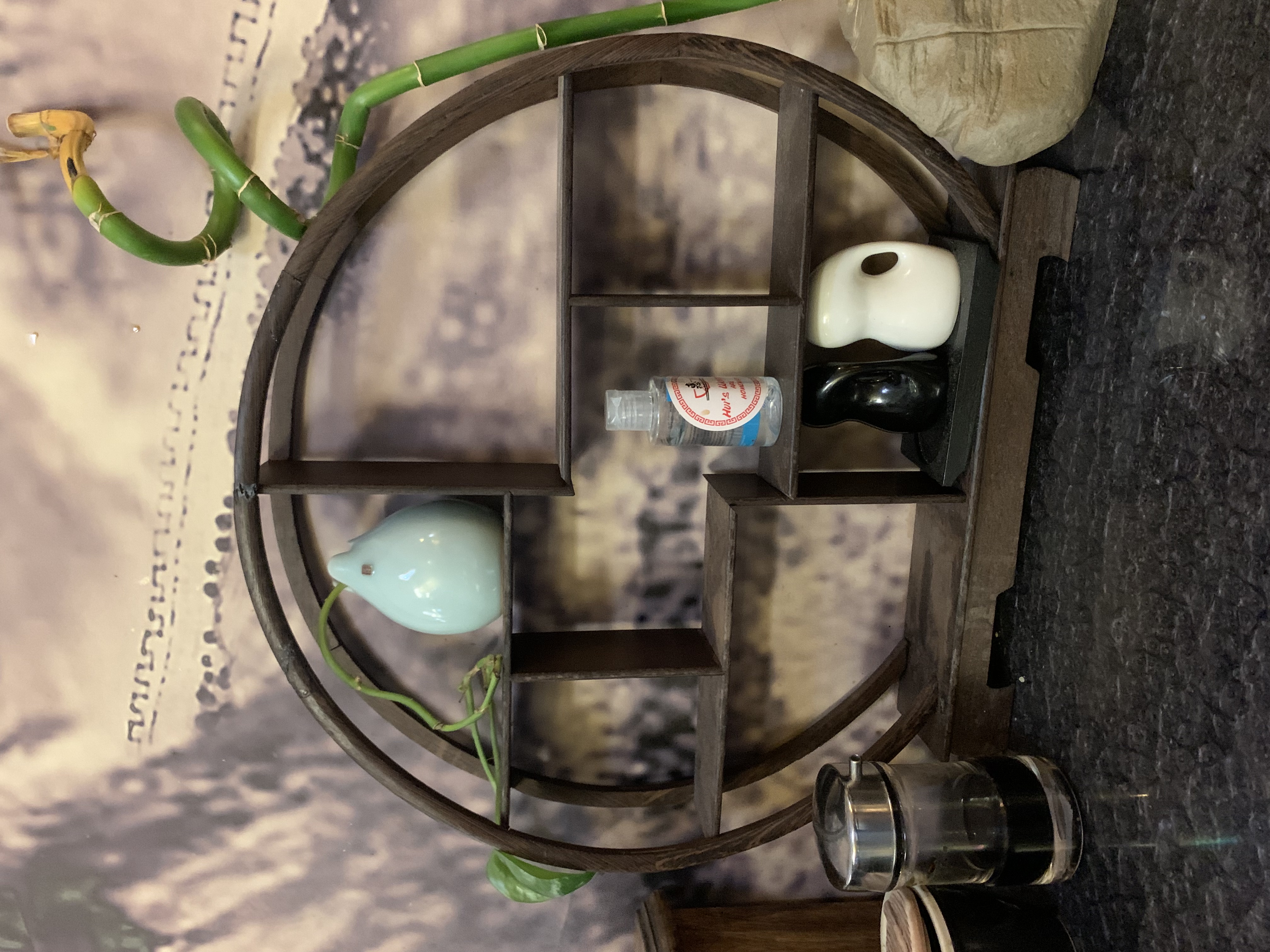 A circle-shaped shelf with small bottles on it.